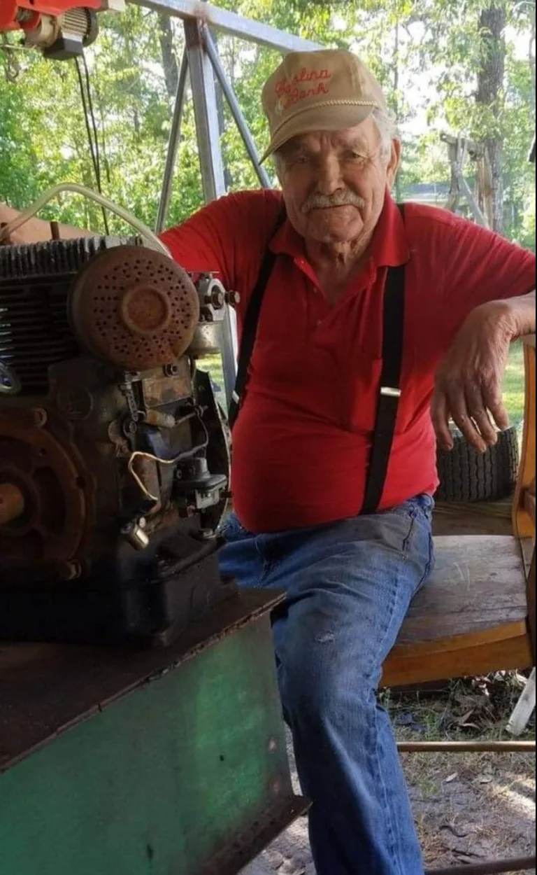 Coy Lee Campbell Senior seated beside machinery
